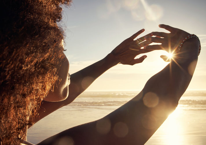 Woman with her hands to the sun on a beach